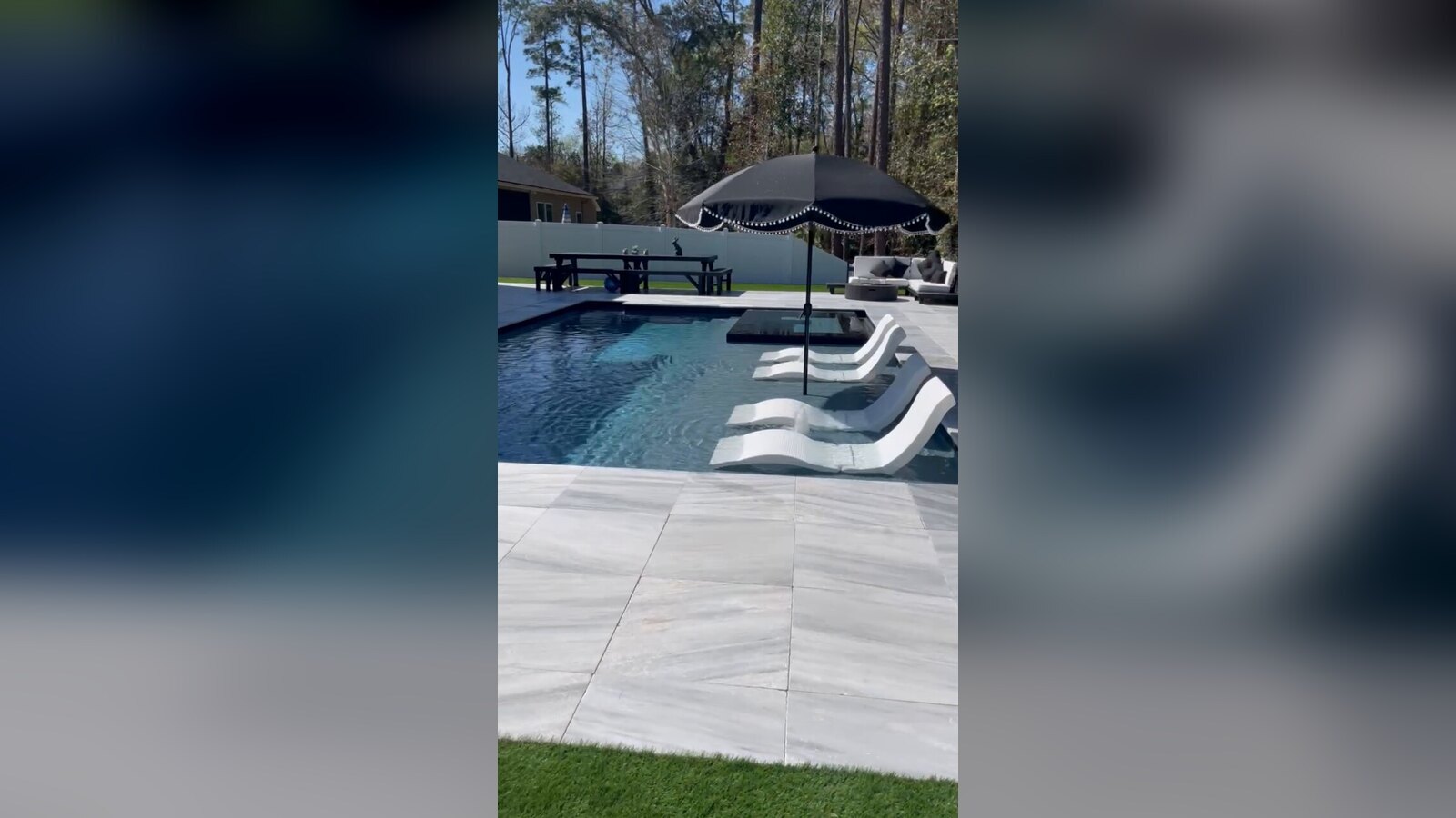 Completed Mandarin backyard pool project with synthetic turf, pool decking and retaining walls, shown in a frame from the supplied final walkthrough.