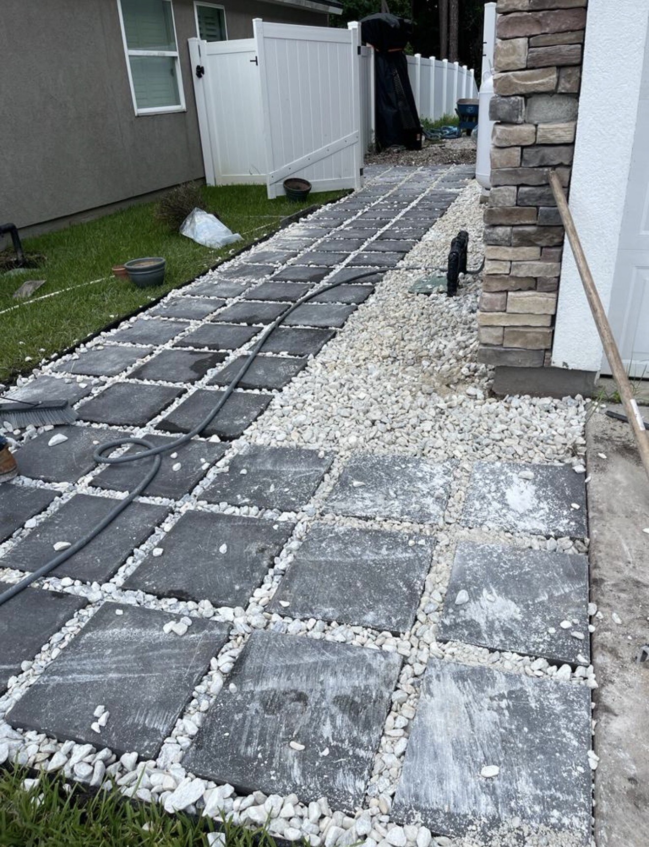 Closer view of pavers and gravel being installed along the Mandarin home's side yard.