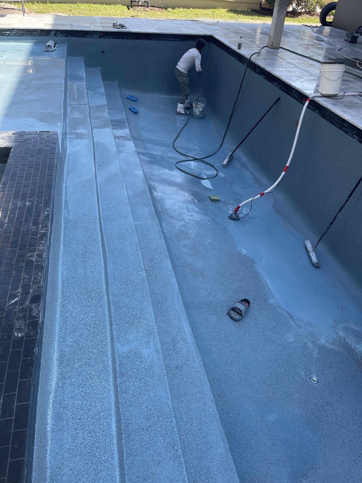 Later construction view of the pool, deck and surrounding backyard.
